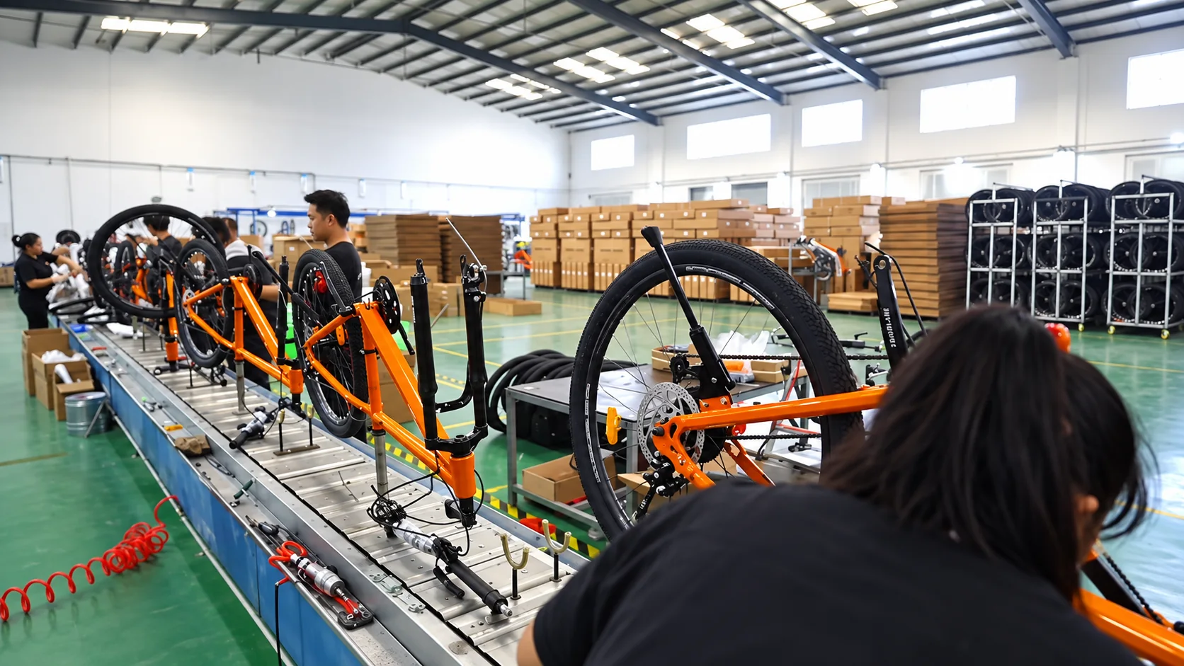 Orange bicycles being assembled at workstations